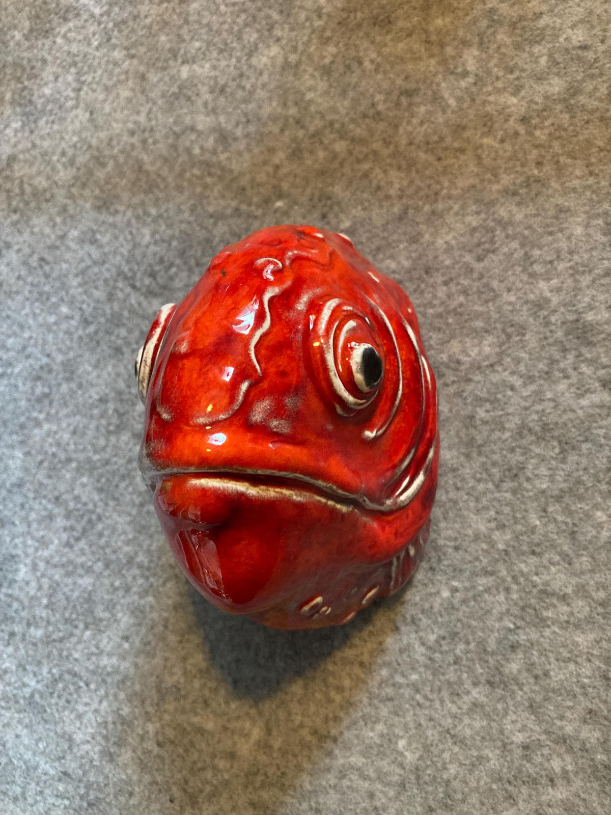 Handmade ceramic Fish wall sculpture, showing its coral red glaze.