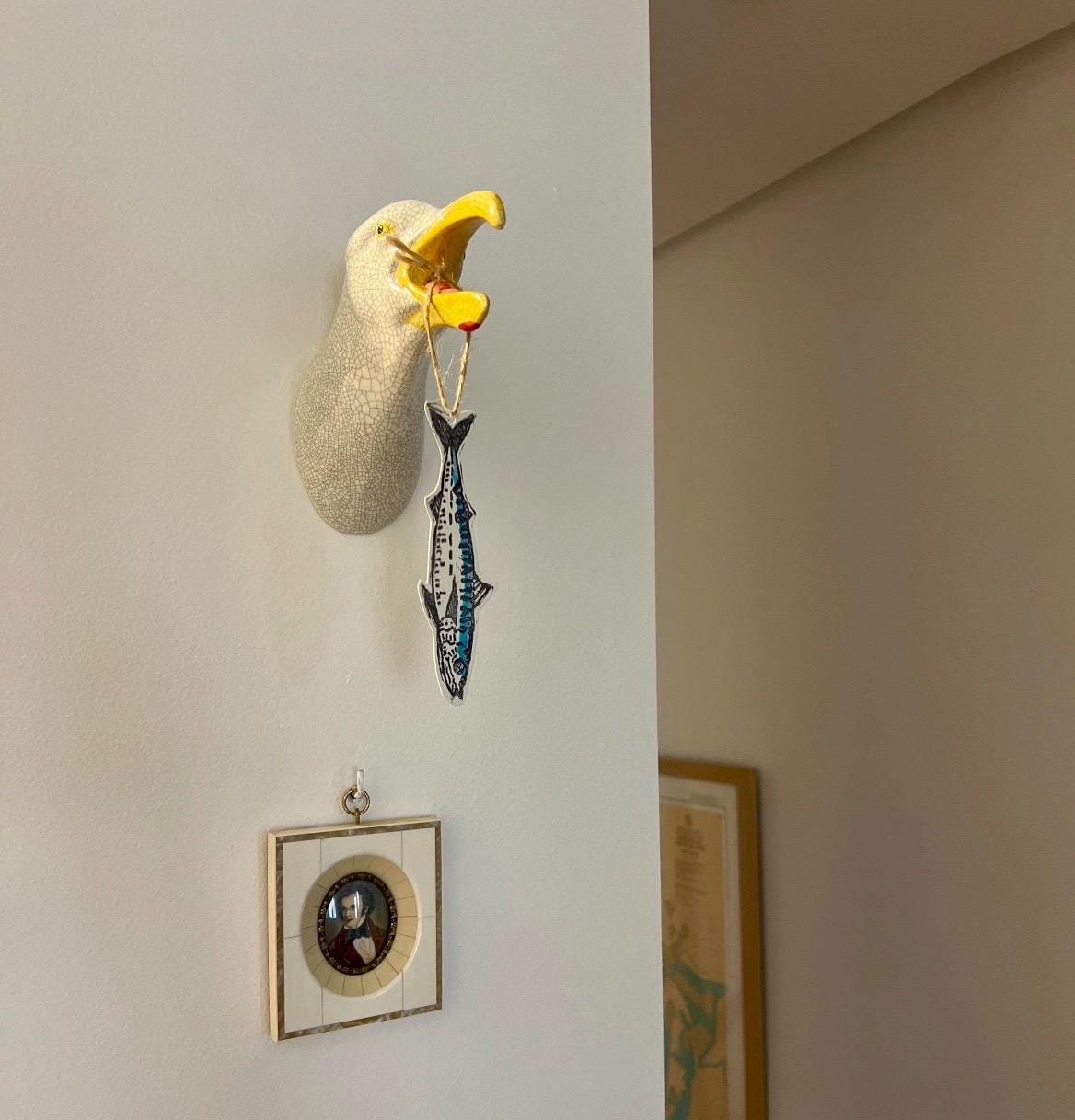 Handmade ceramic Squawking Seagull hanging on a hallway wall.
