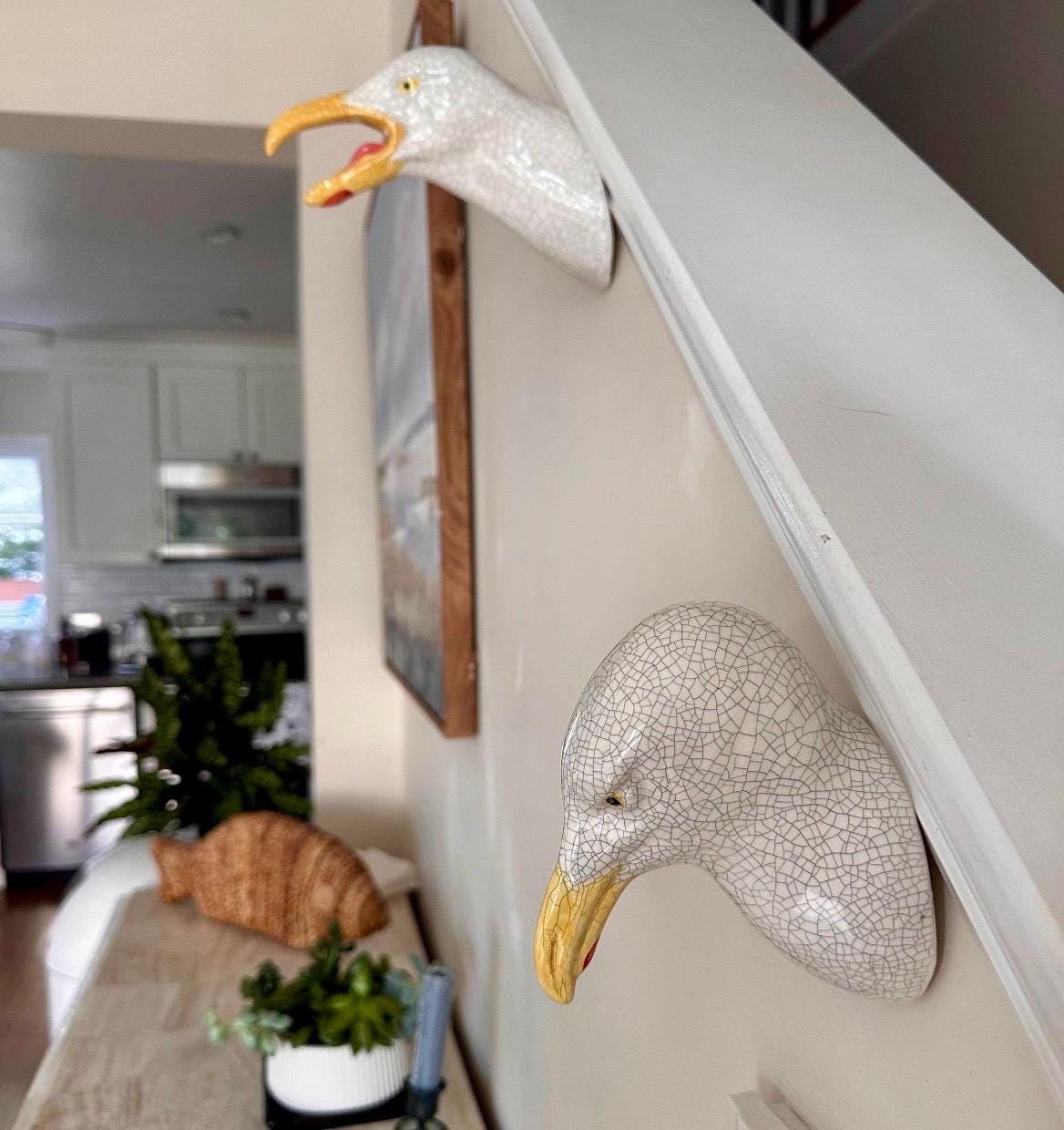 Handmade ceramic Seagull wall sculpture on staircase wall.