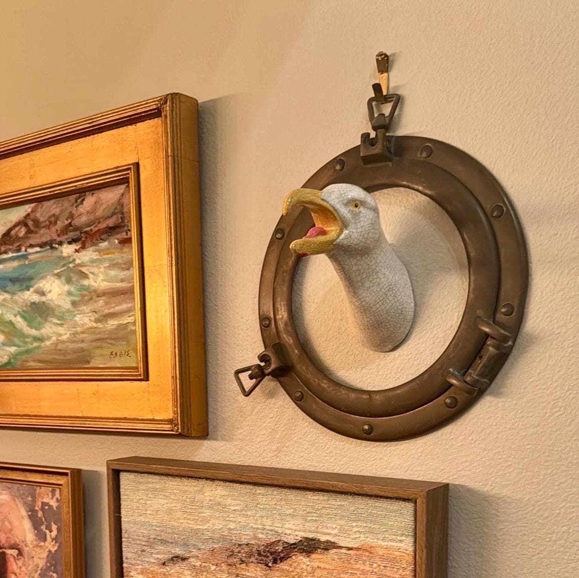 Handmade ceramic Squawking Seagull in an old ship port hole